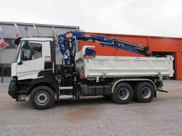 CACES R490 — grue auxiliaire sur camion déchargeant des palettes de matériaux BTP sur un chantier résidentiel de négoce
